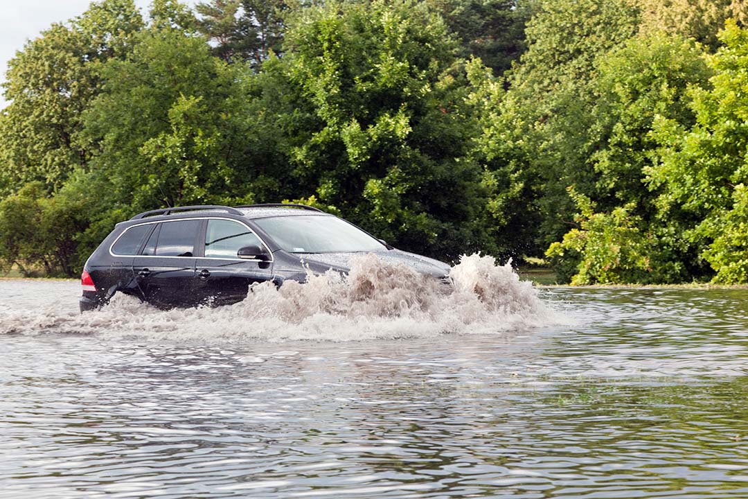 Car driving into flood