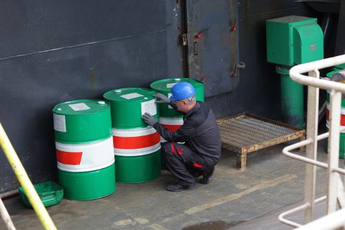A food chemical safety image of a person inspecting containers.