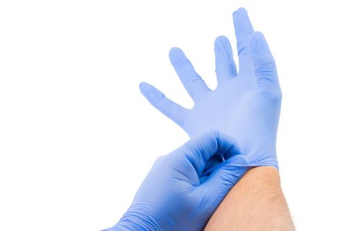 A food chemical safety image of a person putting on gloves.
