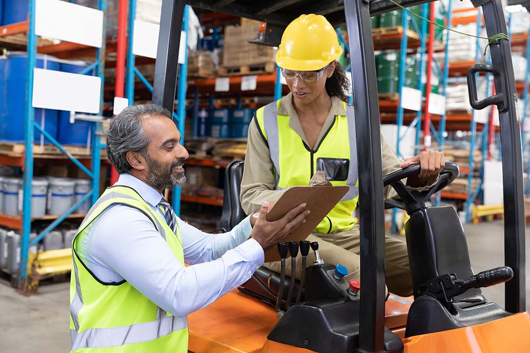 Supervisor talking with employee on forklift