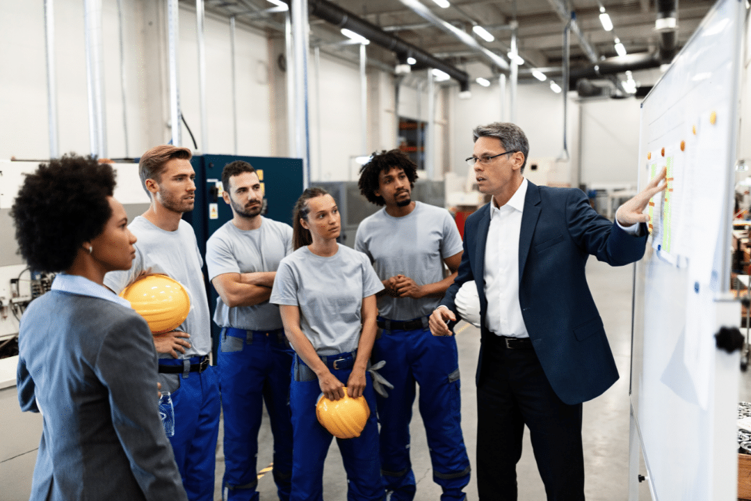 Employees having a safety meeting inside a plant