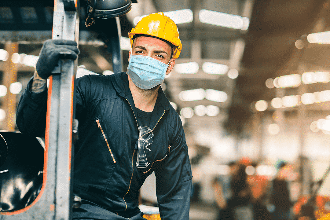 warehouse employee following regulation in face mask