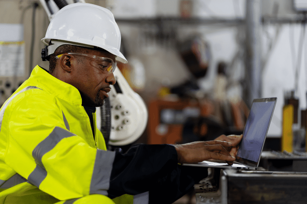 construction worker reportingon laptop