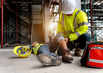 construction employee conducting first aid on injured coworker
