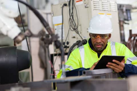 Engineer worker using tablet to perform machine safety inspection